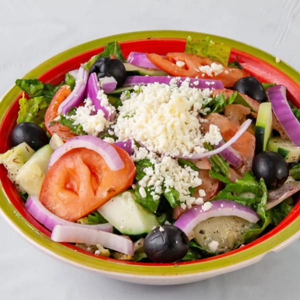 KINZI's Mediterranean salad with lettuce, tomatoes, red onions, olives, cucumbers, and feta cheese.